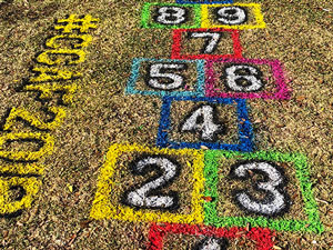 Spray chalk hopscotch game on grass