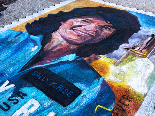 Posing with Sally Ride stamp pavement chalk art side view