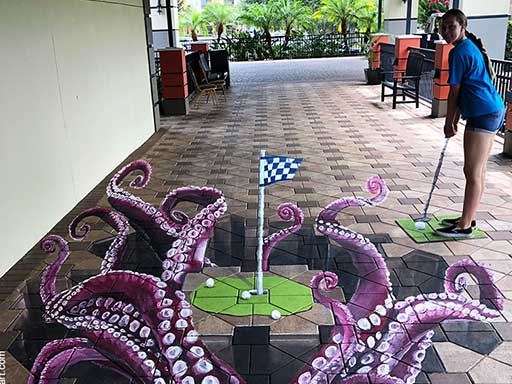 Posing with golf putting green with octopus tentacles 3D pavement art