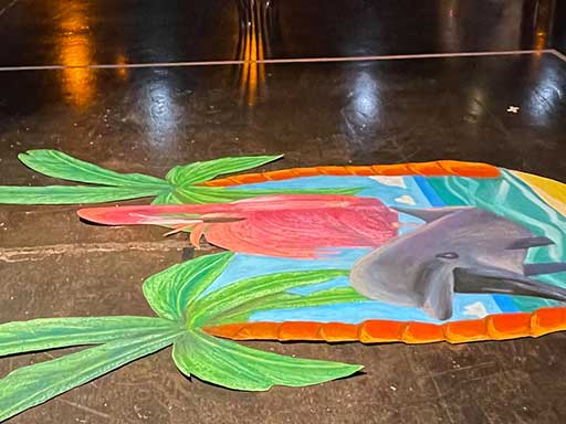 Side view of 3D chalk image of palm trees dolphin and flamingo