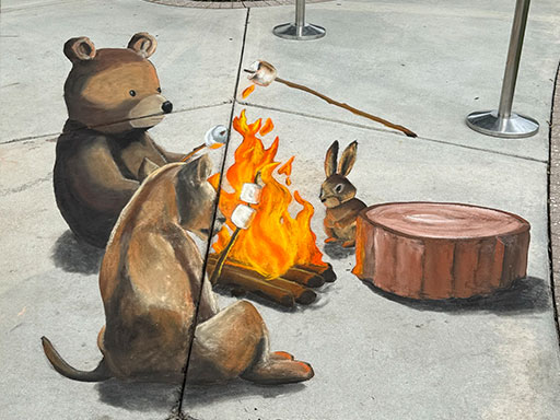 3D chalk image of forest animals toasting marshmallows around a fire.