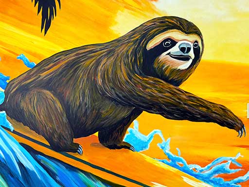 Detail of wall mural featuring a sloth surfing on a surfboard against a bright tropical sunset background