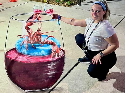 Posing with chalk art of lobster floating on pool floatie inside a wine glass
