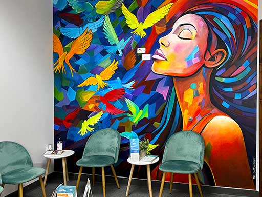 Angle view of colorful abstract wall mural with woman's profile and birds