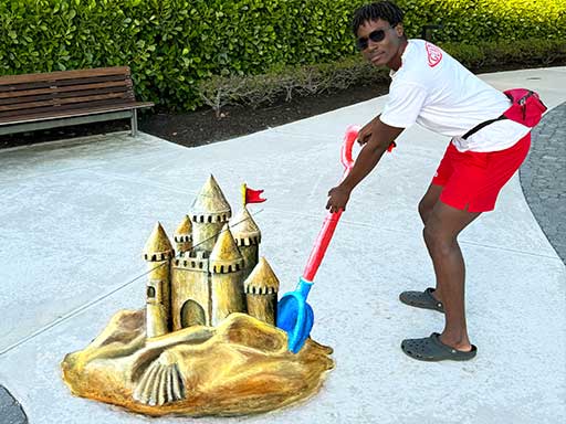 Interactive 3D chalk art of a shovel digging a sand castle.